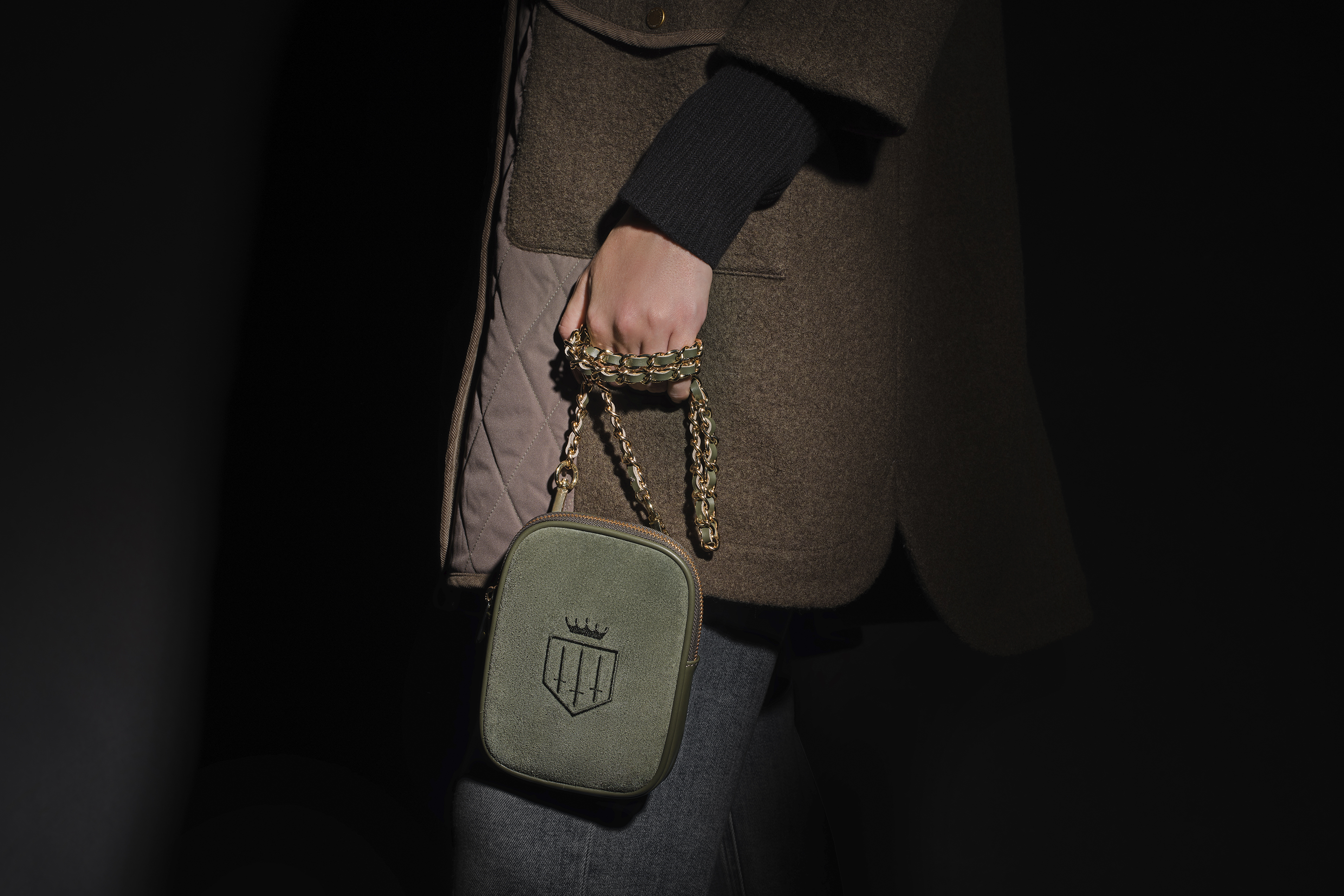 advertising photo shoot A/W for Fairfax and favor close up shot model holding a handbag dark moody lighting black backdrop